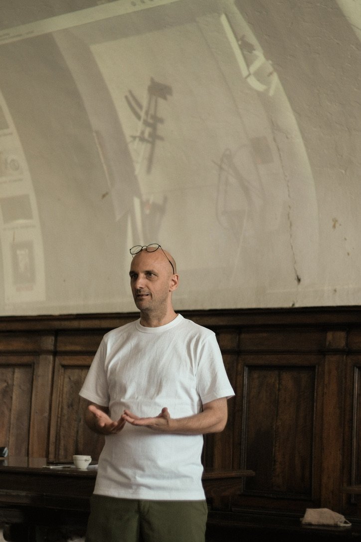A lecturer speaking in front of a projection in the convent hall