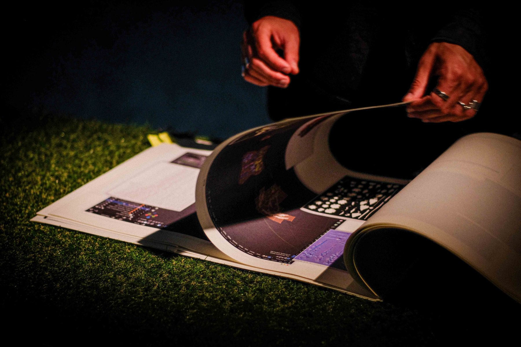 Hands turning the pages of a large process booklet