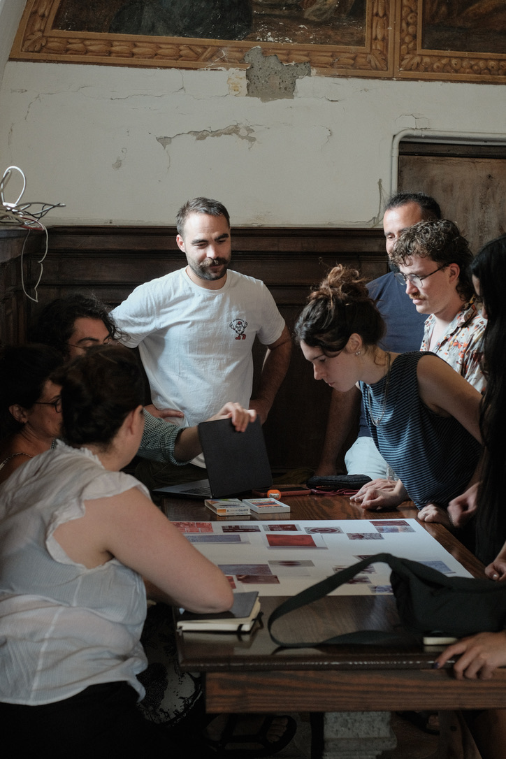 Participants gathered around the collage in discussion